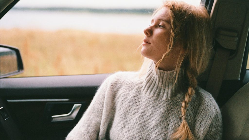 woman sitting in car looking out window