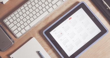 calendar on iPad next to computer keyboard