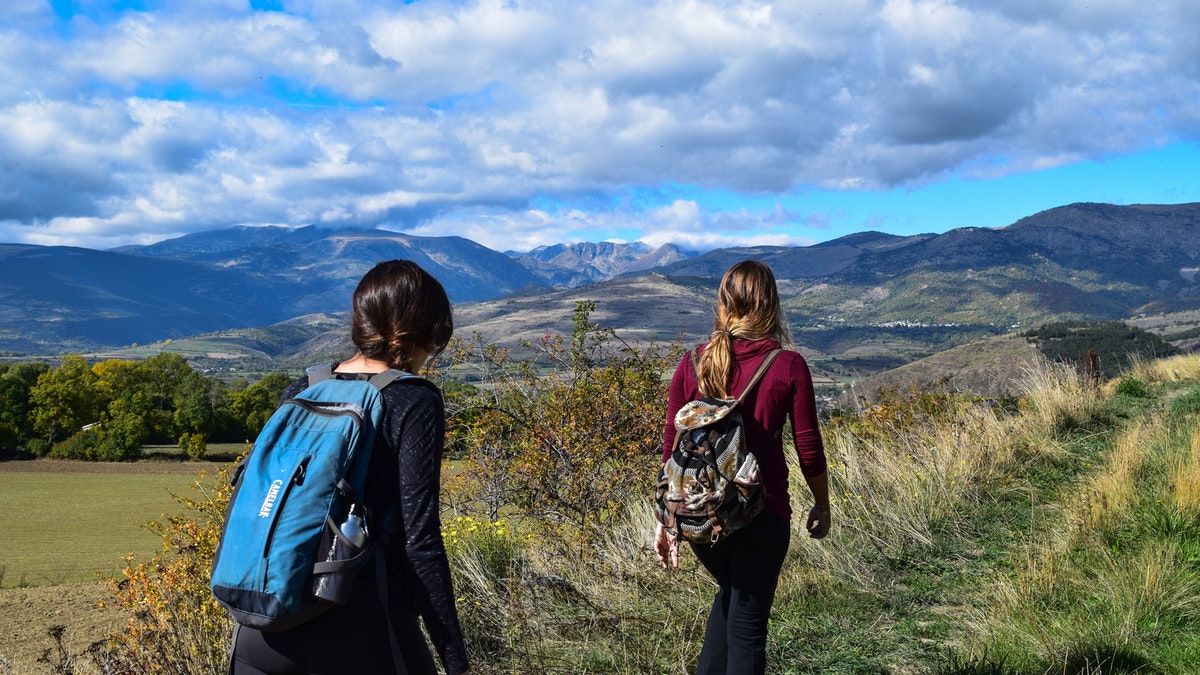 two people hiking, mountains in the distance