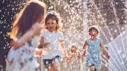 kids play sprinkler yard