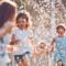 kids play sprinkler yard