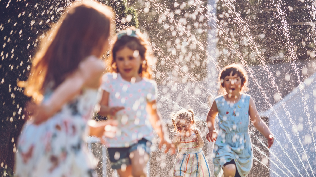 kids play sprinkler yard